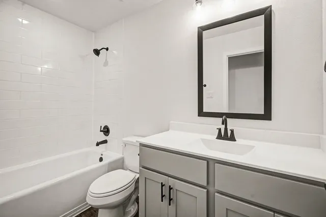 a bathroom with a sink toilet vanity and tub