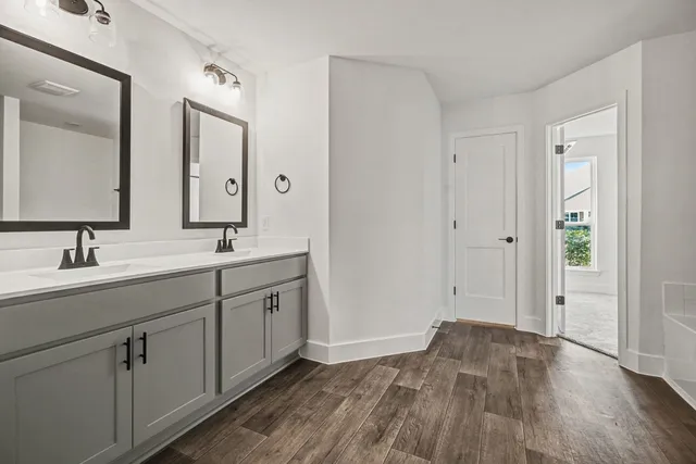 a spacious bathroom with a double vanity sink and mirror