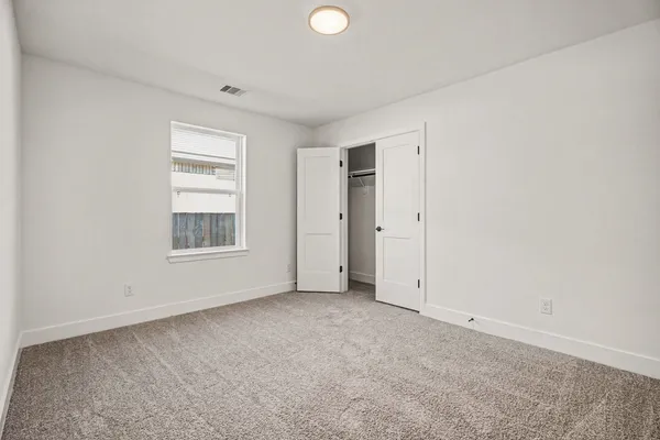 an empty room with windows and closet