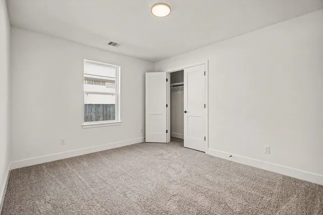 an empty room with windows and closet