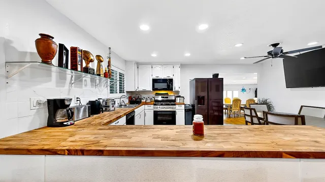 a kitchen with stainless steel appliances kitchen island granite countertop a refrigerator oven a sink and dishwasher