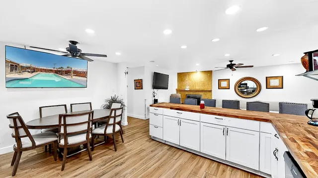 a kitchen with a dining table chairs and white cabinets