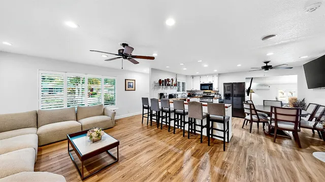 a living room with furniture wooden floor dining table and a window