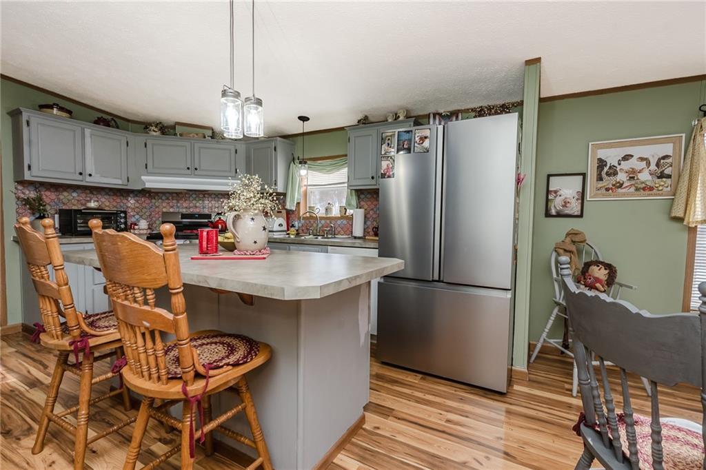 464 Rte 119 Highway North Indiana, PA 15701 - Photo 11 of 37 a kitchen with granite countertop a refrigerator a stove a sink and white cabinets with wooden floor