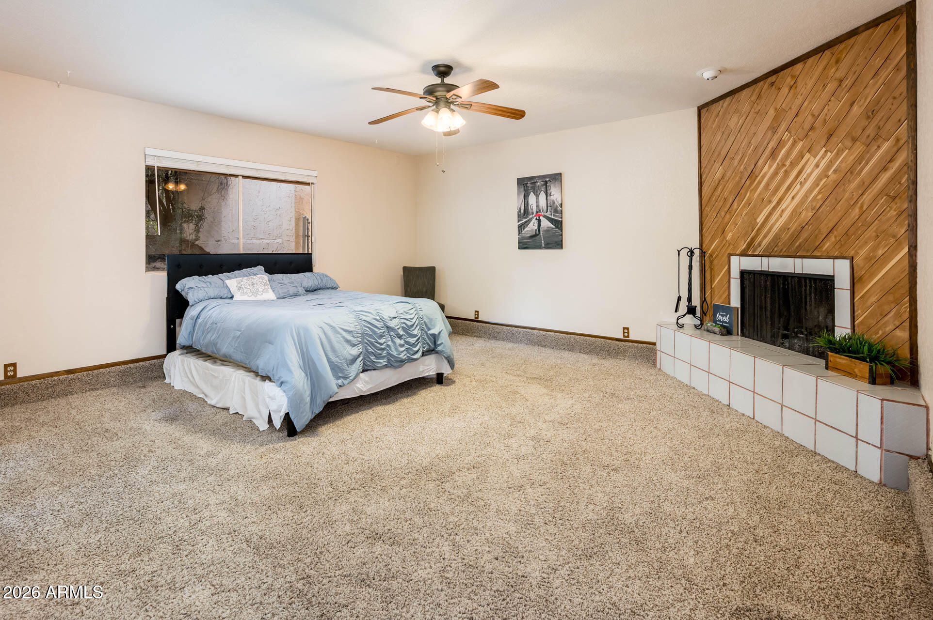7027 West Wagoner Road Glendale, AZ 85308 - Photo 14 of 29 a spacious bedroom with a bed and a fireplace