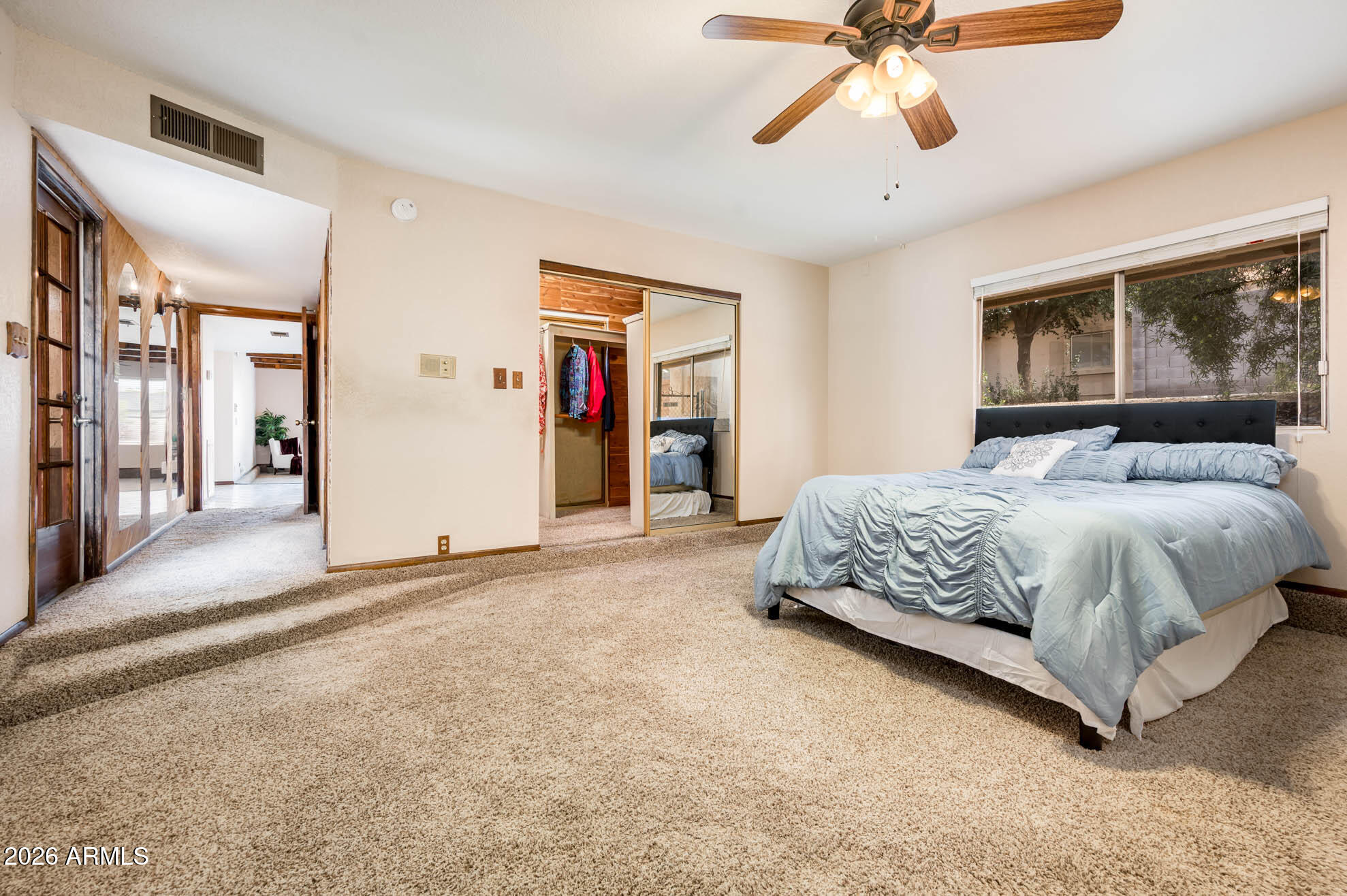 7027 West Wagoner Road Glendale, AZ 85308 - Photo 15 of 29 a bedroom with a large bed and a chandelier