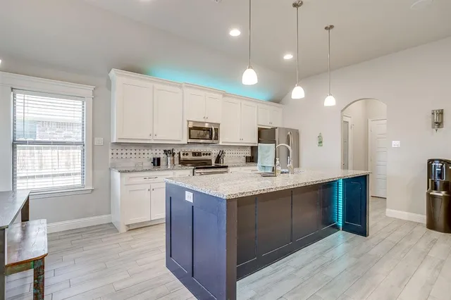 a view of kitchen with stainless steel appliances granite countertop cabinets and wooden floor