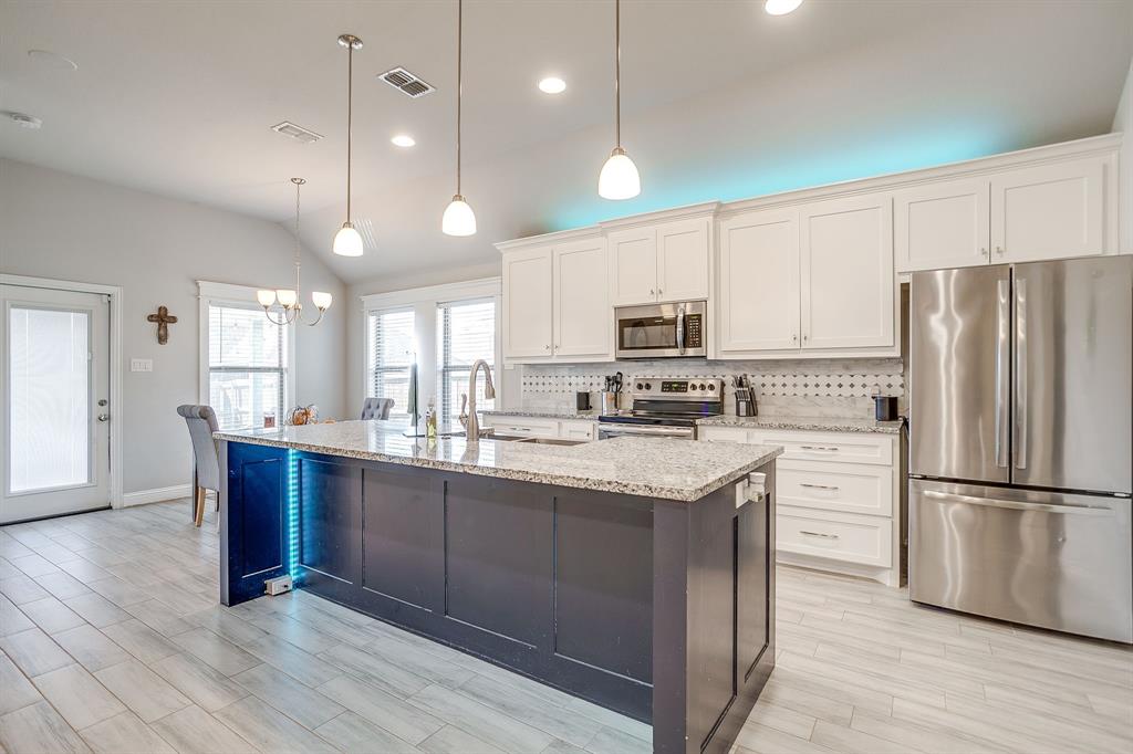 940 Sam Street Springtown, TX 76082 - Photo 13 of 39 a kitchen with stainless steel appliances granite countertop a refrigerator a sink dishwasher a stove and white cabinets with wooden floor