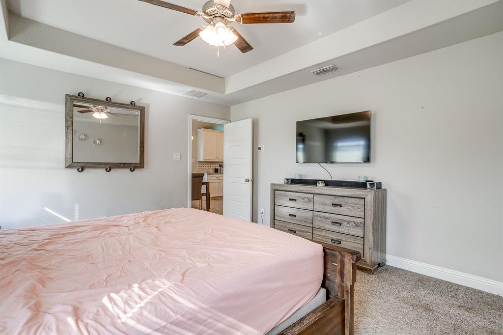 940 Sam Street Springtown, TX 76082 - Photo 23 of 39 a bedroom with a bed and a flat screen tv