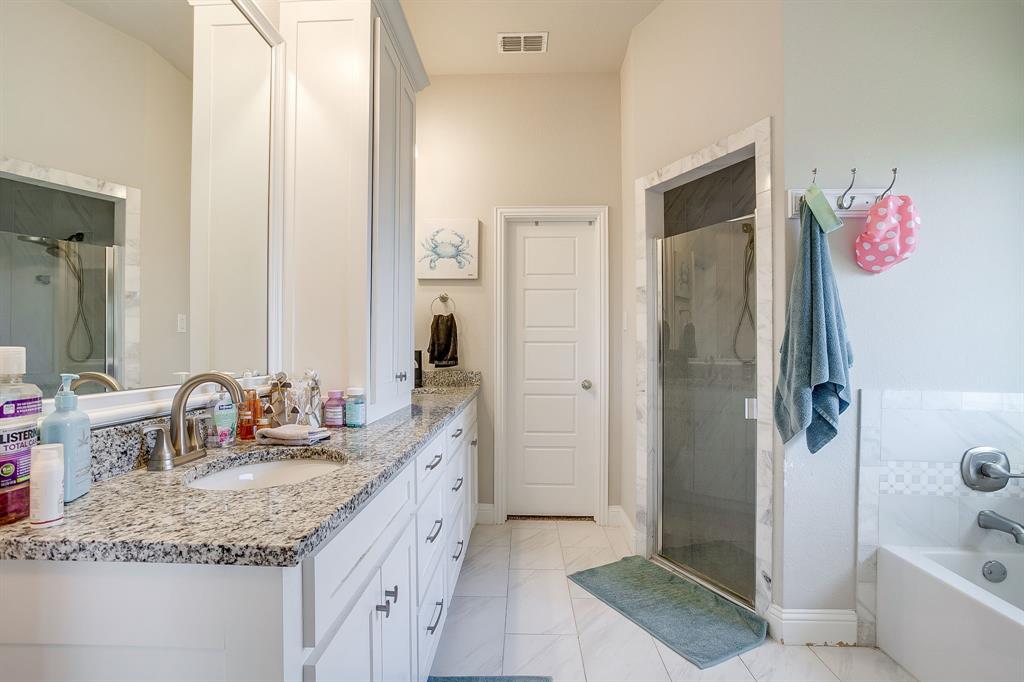 940 Sam Street Springtown, TX 76082 - Photo 25 of 39 a bathroom with a granite countertop sink a shower and a mirror