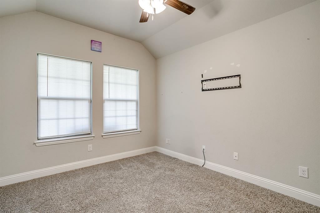 940 Sam Street Springtown, TX 76082 - Photo 29 of 39 an empty room with chandelier fan and windows