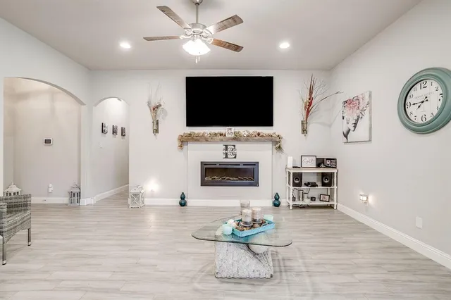 a living room with furniture a flat screen tv and a fireplace