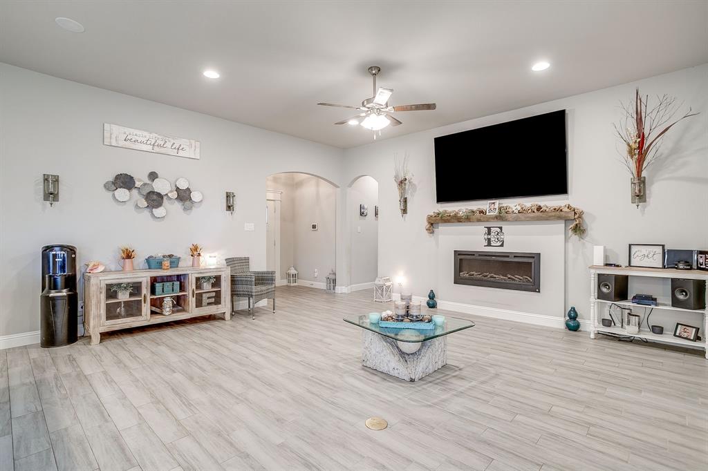 940 Sam Street Springtown, TX 76082 - Photo 9 of 39 a living room with furniture a flat screen tv and a fireplace