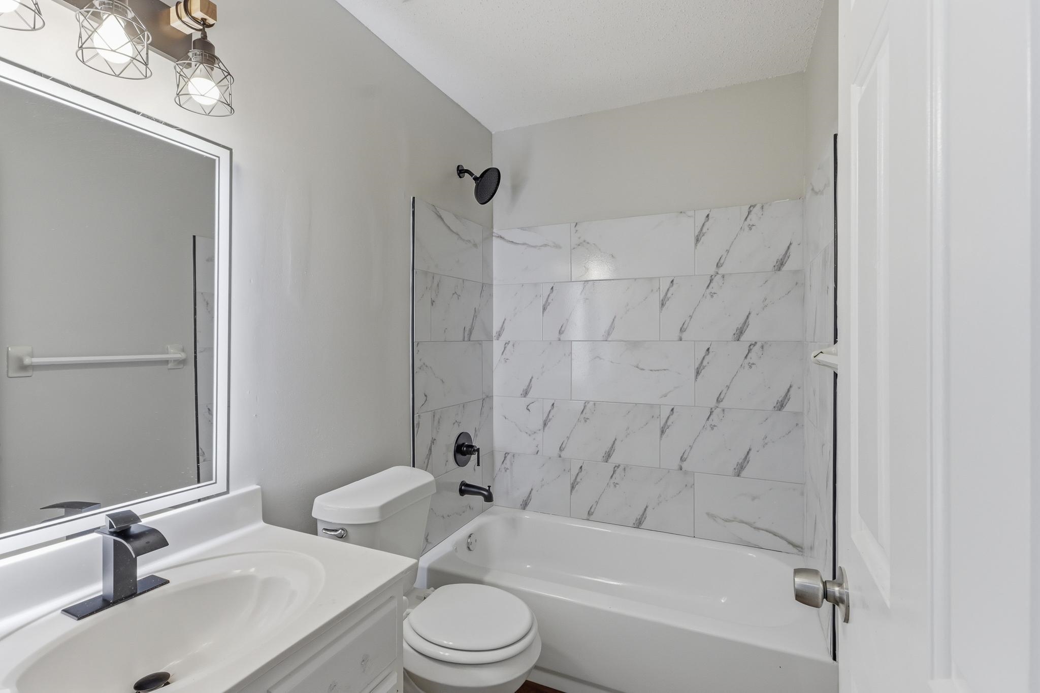 4101 Long Creek Road Memphis, TN 38125 - Photo 24 of 36 Bathroom featuring a white vanity with an integrated sink, black faucet, and frameless mirror