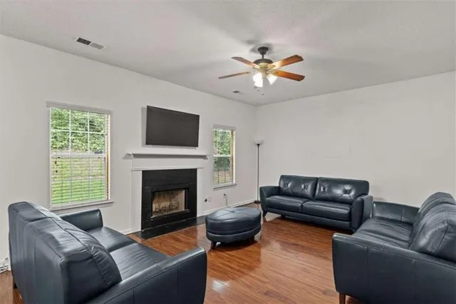 a living room with furniture a fireplace and a flat screen tv
