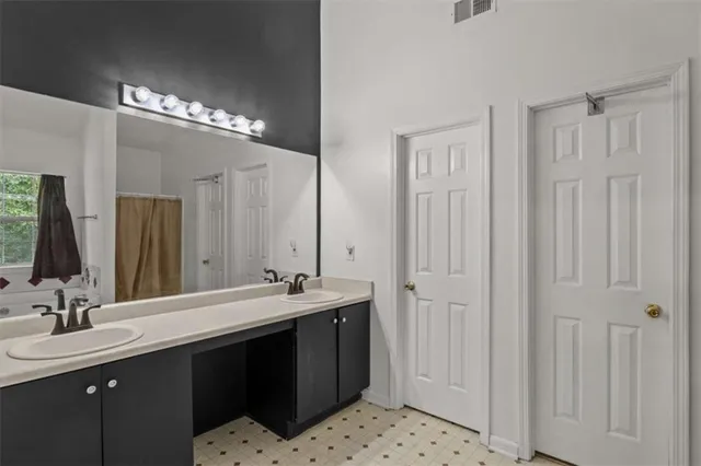 a bathroom with double sink and a mirror