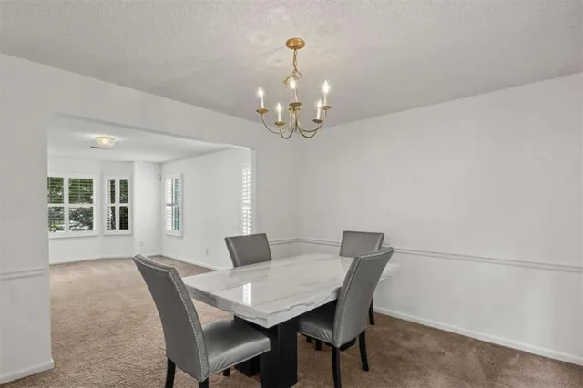 a view of a dining room with furniture and chandelier