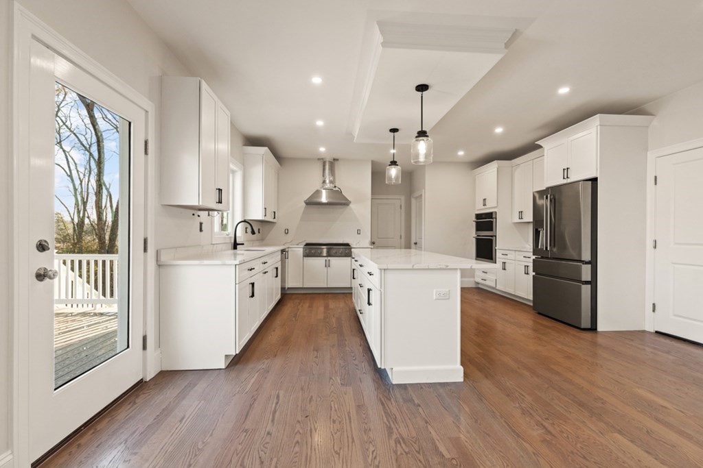 21 Vera Road Middleton, MA 01949 - Photo 13 of 41 a kitchen with stainless steel appliances a refrigerator a sink dishwasher a oven and a dining table with wooden floor