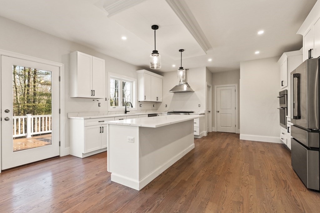 21 Vera Road Middleton, MA 01949 - Photo 14 of 41 a large kitchen with kitchen island wooden floors white cabinets and stainless steel appliances