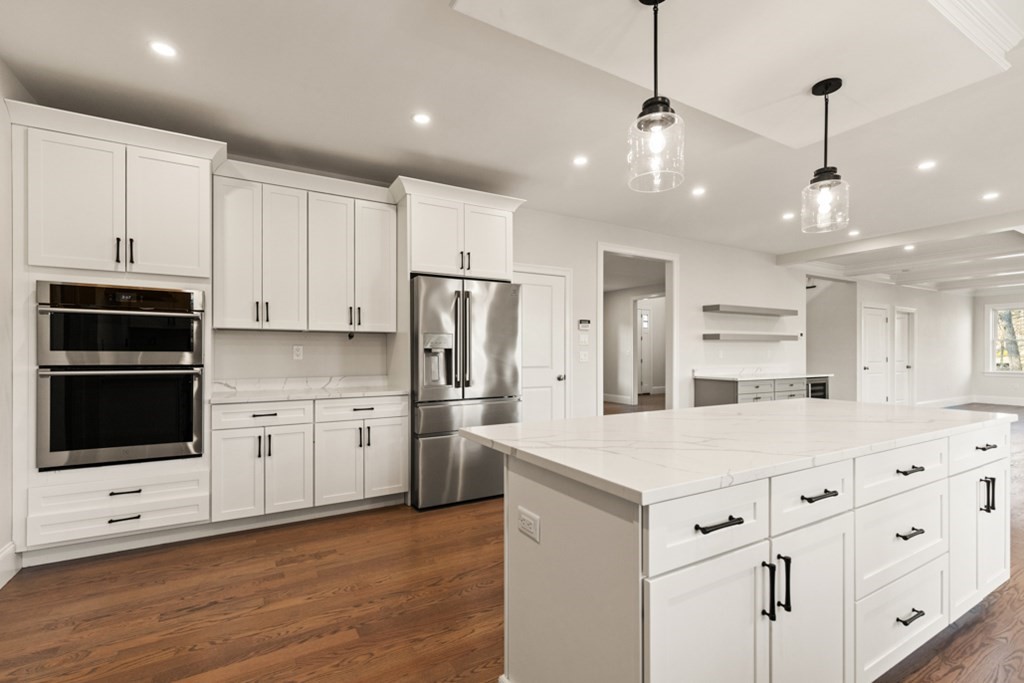 21 Vera Road Middleton, MA 01949 - Photo 16 of 41 a kitchen with stainless steel appliances kitchen island granite countertop a refrigerator a stove and white cabinets with wooden floor