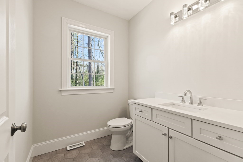 21 Vera Road Middleton, MA 01949 - Photo 23 of 41 a bathroom with a toilet a sink a mirror and a window