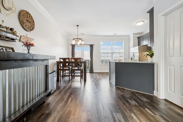 an empty room with wooden floor and a clock on wall