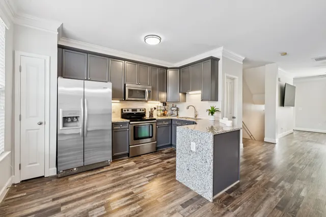a kitchen with kitchen island a counter top space cabinets and stainless steel appliances