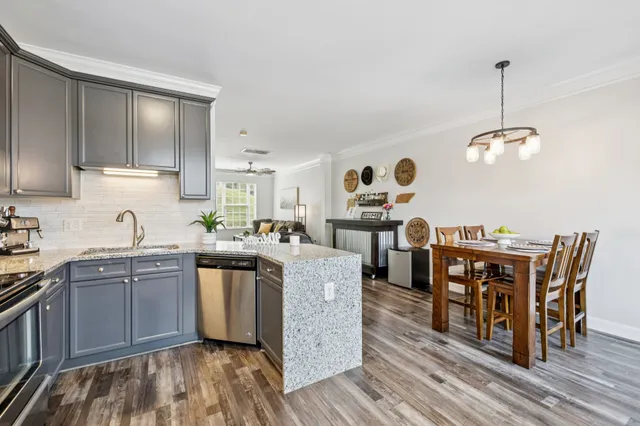 a kitchen with stainless steel appliances granite countertop a stove and a wooden floors