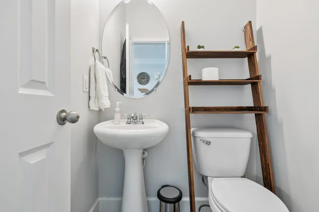 a bathroom with a toilet sink and mirror