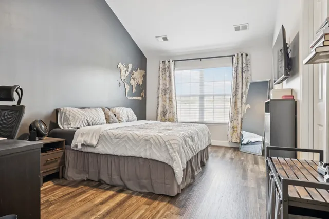 a bedroom with a bed and wooden floor