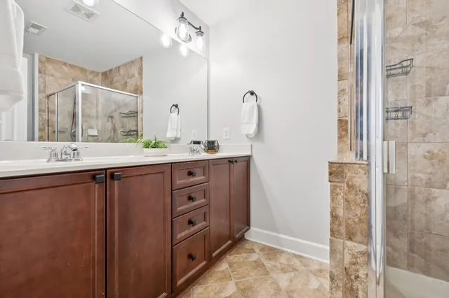 a bathroom with a double vanity sink a mirror and a shower
