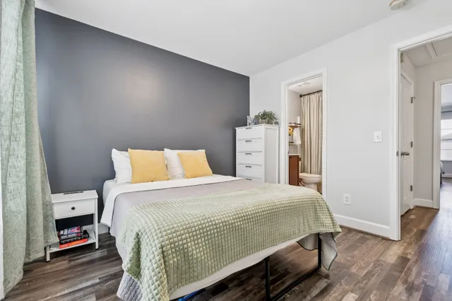 a bedroom with a bed and wooden floor