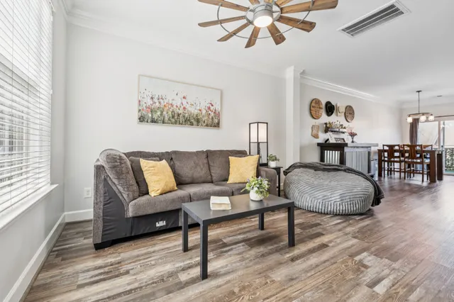 a living room with furniture and a wooden floor