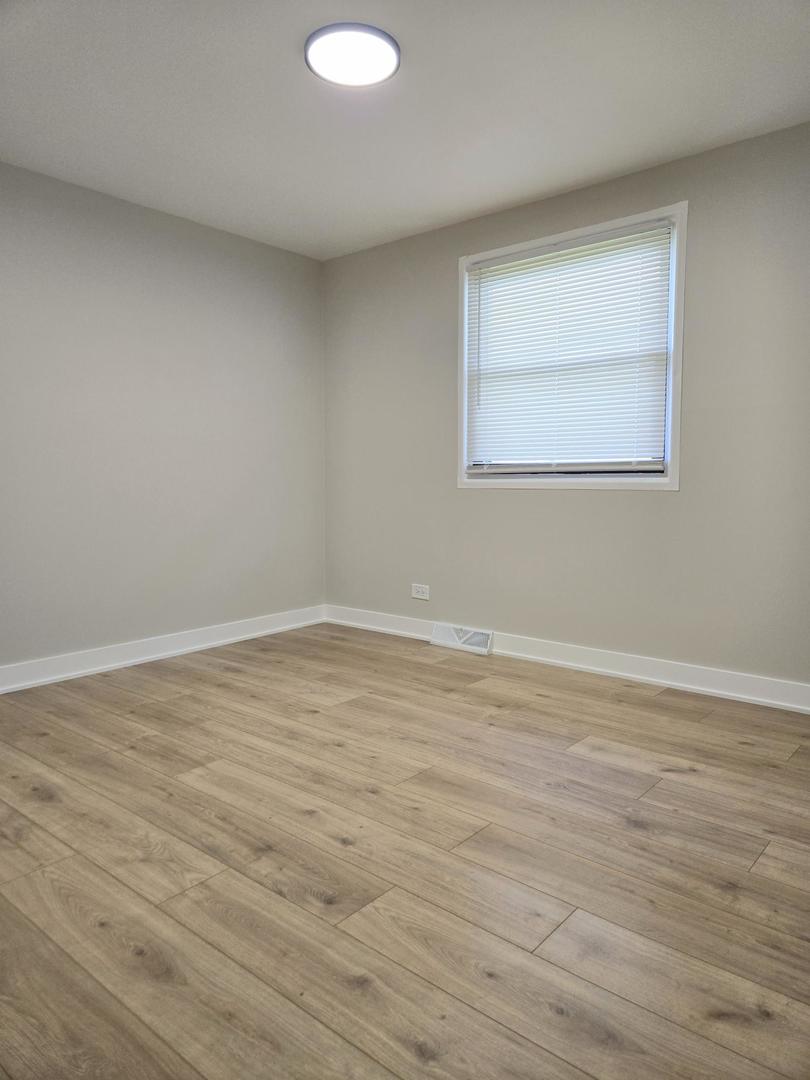 16536 Wolcott Avenue Markham, IL 60428 - Photo 11 of 18 a view of a room with wooden floor and white walls