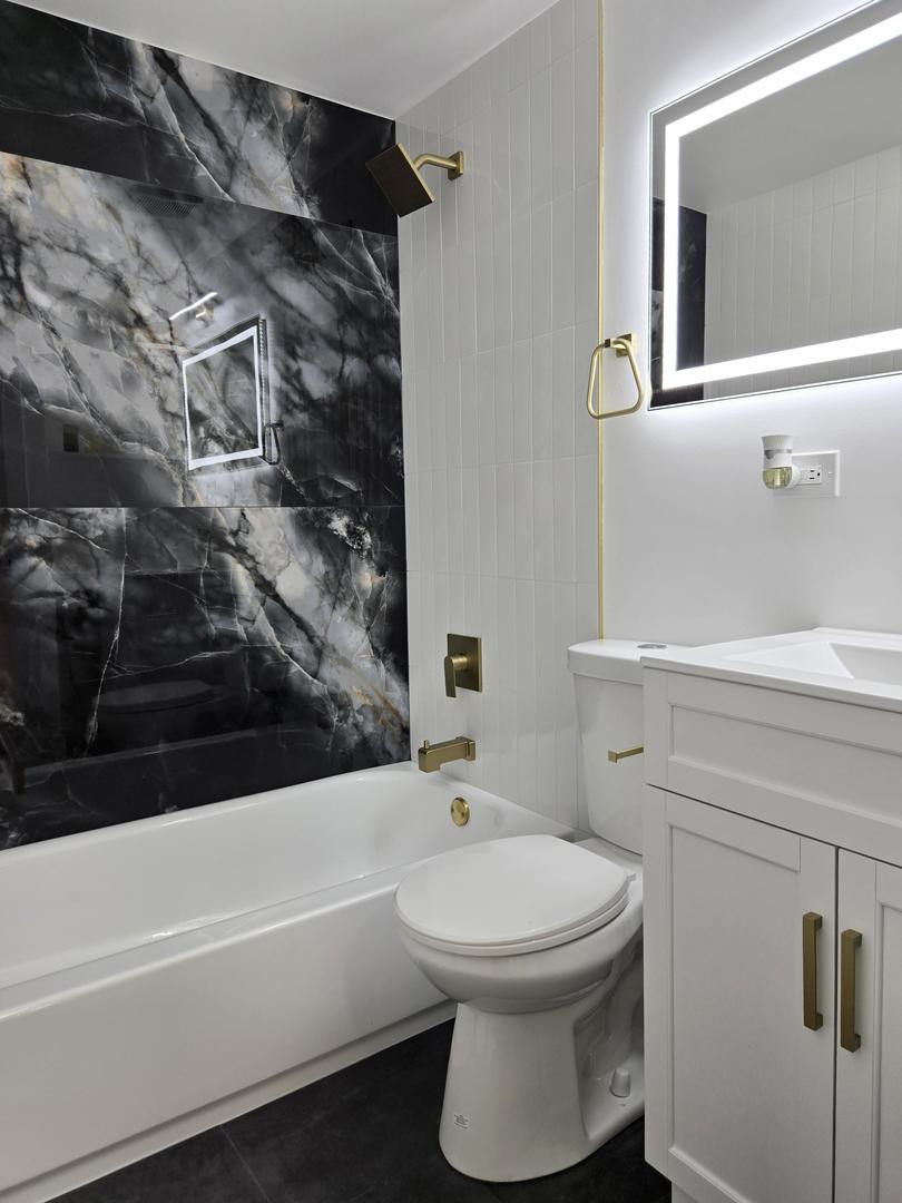 16536 Wolcott Avenue Markham, IL 60428 - Photo 12 of 18 a bathroom with a bathtub and a toilet