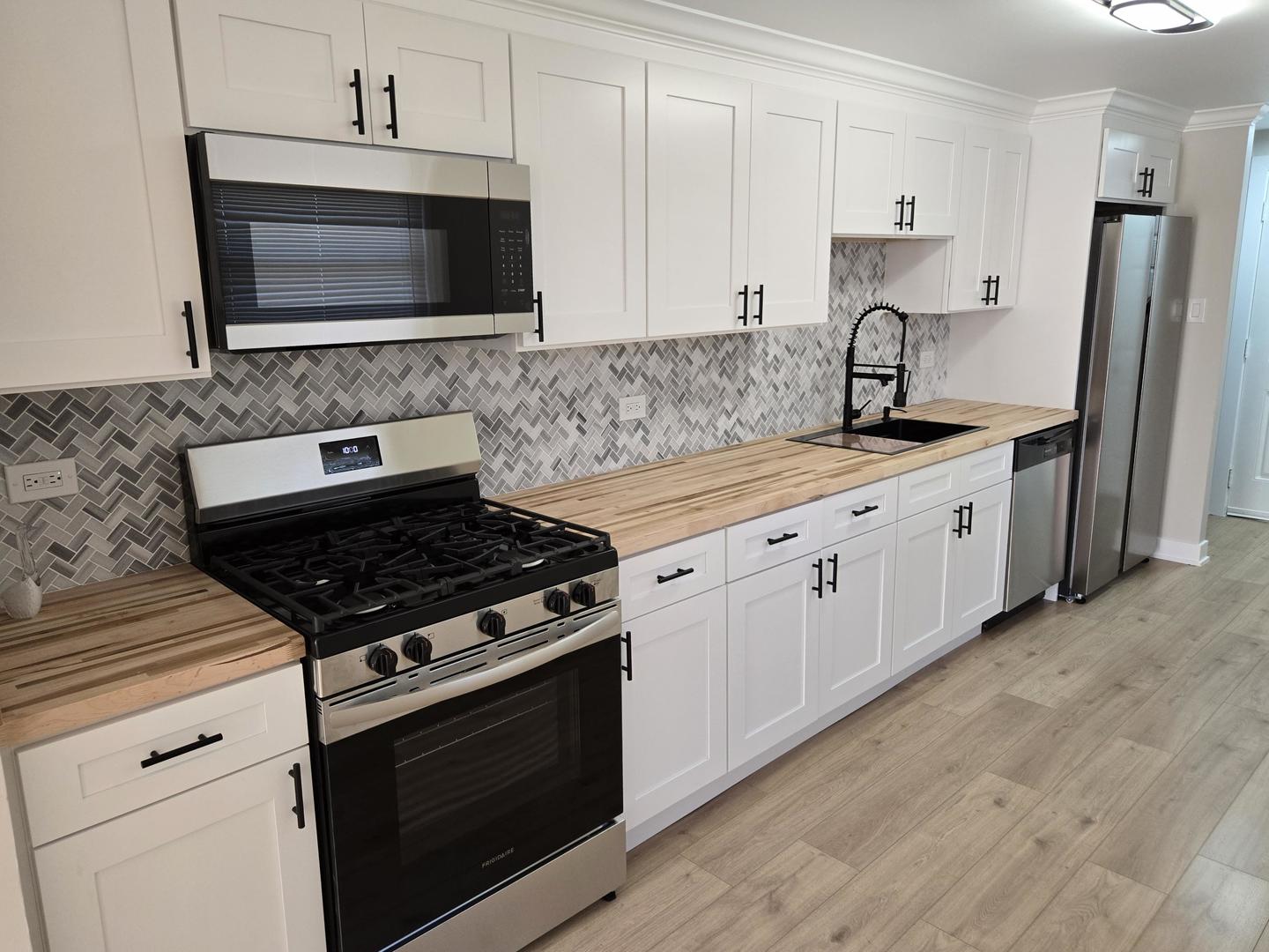 16536 Wolcott Avenue Markham, IL 60428 - Photo 6 of 18 a kitchen with stainless steel appliances a stove a sink and a microwave