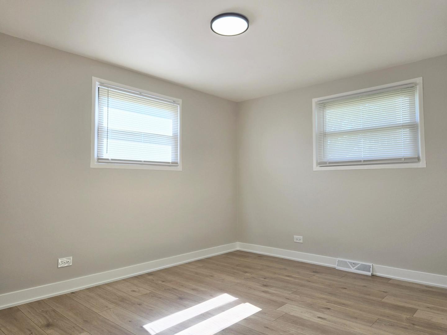 16536 Wolcott Avenue Markham, IL 60428 - Photo 8 of 18 an empty room with wooden floor and windows