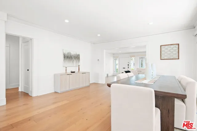 a large white kitchen with a window a sink and a refrigerator