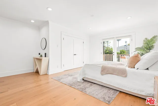 a spacious bedroom with a bed a couch and a potted plant