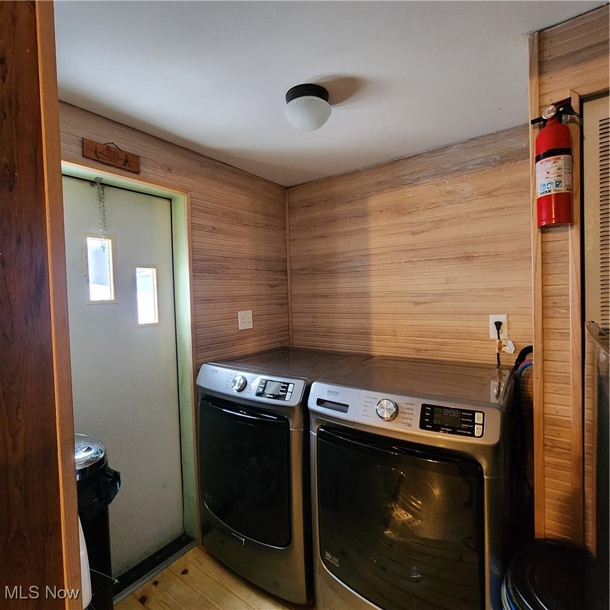6487 Klass Road Cambridge, OH 43725 - Photo 9 of 20 Laundry room with wooden walls, washing machine and clothes dryer, and light wood-style floors