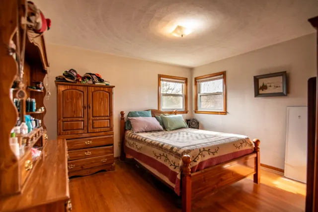 a bedroom with a bed and wooden floor
