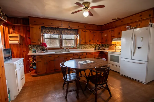 a kitchen with a table chairs refrigerator and sink