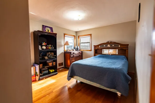 a bed sitting in a bedroom next to a window