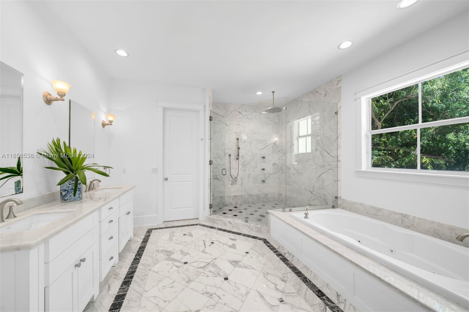 4050 Battersea Road Coconut Grove, FL 33133 - Photo 14 of 40 a bathroom with a granite countertop tub a sink and a large mirror