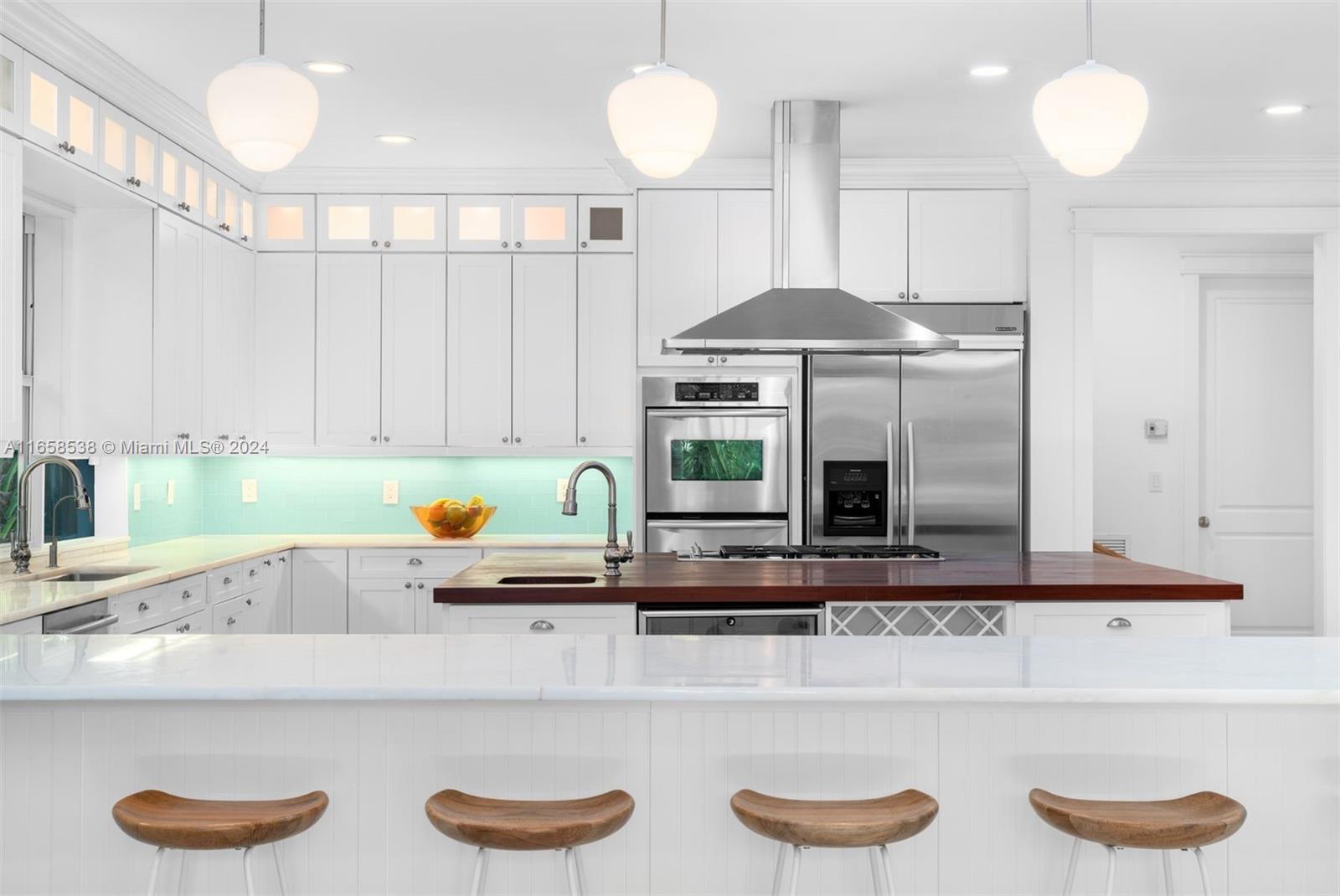 4050 Battersea Road Coconut Grove, FL 33133 - Photo 31 of 40 a kitchen with stainless steel appliances granite countertop a sink a stove and a wooden cabinets