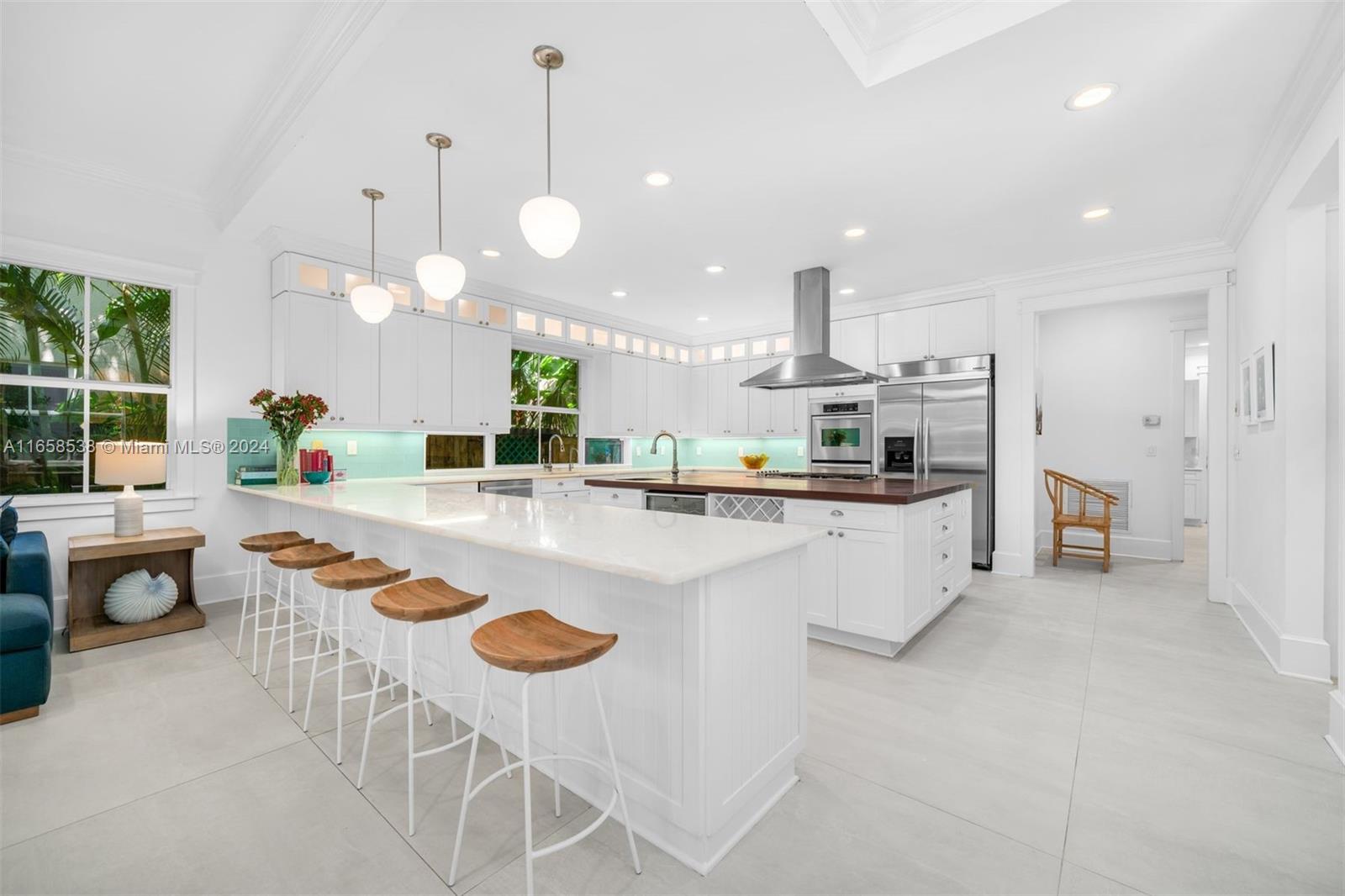 4050 Battersea Road Coconut Grove, FL 33133 - Photo 32 of 40 a kitchen with stainless steel appliances granite countertop a sink and a refrigerator