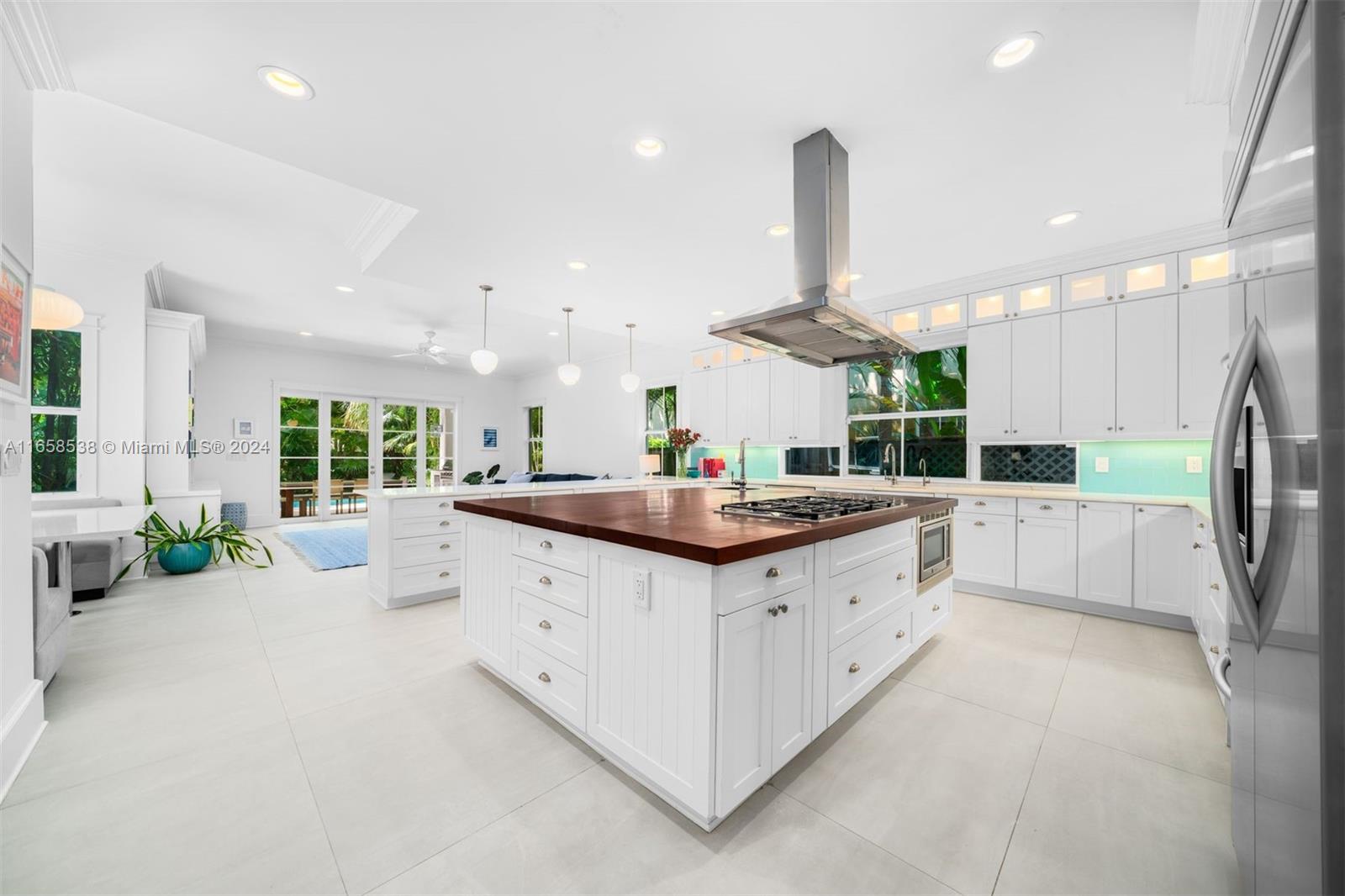 4050 Battersea Road Coconut Grove, FL 33133 - Photo 7 of 40 a kitchen with stainless steel appliances a sink and a large window