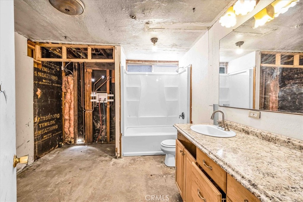 59724 Stearman Road Landers, CA 92285 - Photo 11 of 38 a bathroom with a granite countertop sink and a mirror