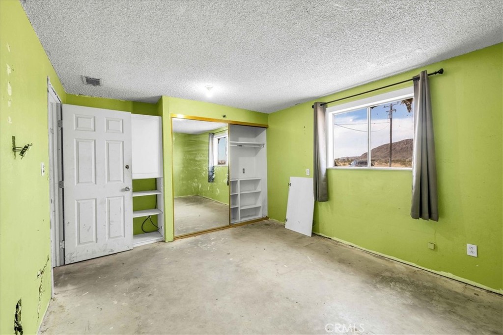 59724 Stearman Road Landers, CA 92285 - Photo 13 of 38 an empty room with a yellow door and a window