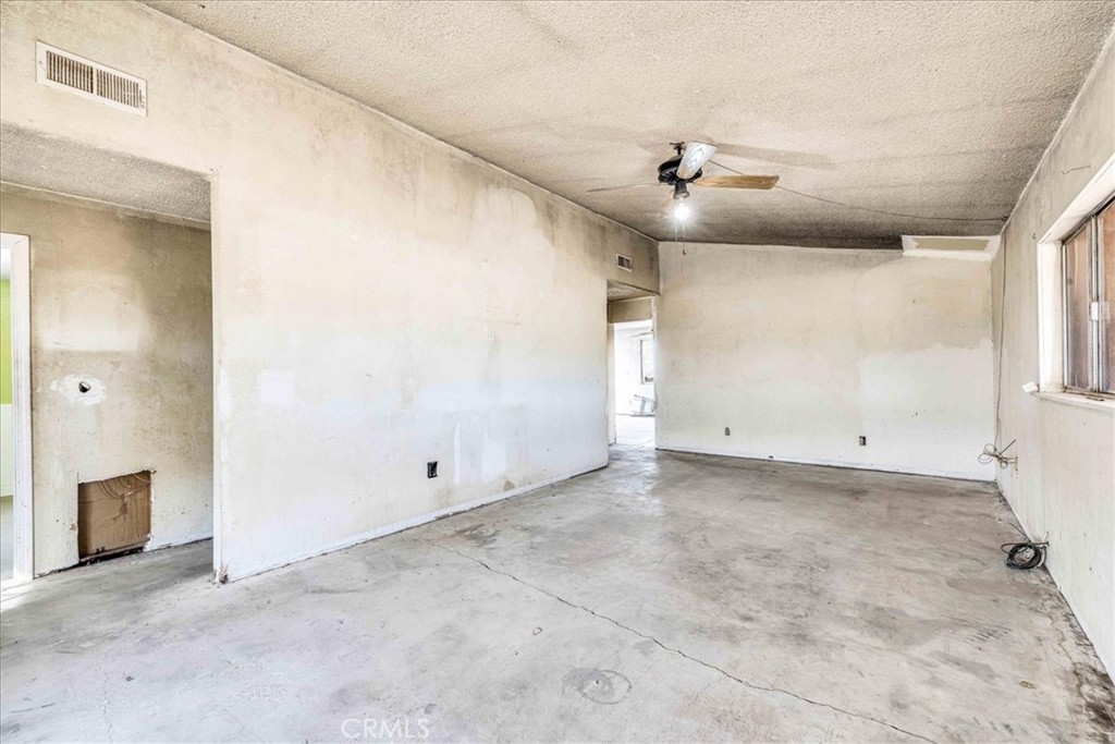 59724 Stearman Road Landers, CA 92285 - Photo 7 of 38 an empty room with chandelier fan and windows